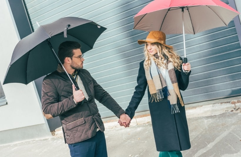 Paar mit Taschenschirm im Regen